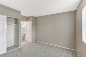 Interior Unit Bedroom, Neutral toned walls, neutral toned carpeting, bathroom in bedroom, sliding door closet.