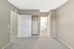 Interior Unit Bedroom, Neutral toned walls, neutral toned carpeting, bathroom in bedroom, sliding door closet.